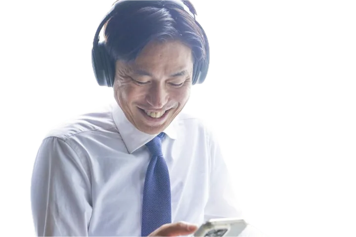 ヘッドホンで英語を聴きながら笑う男性